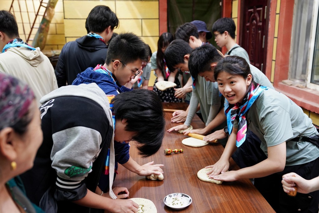 在葡萄溝製作並品嚐特色美食「烤饟」。