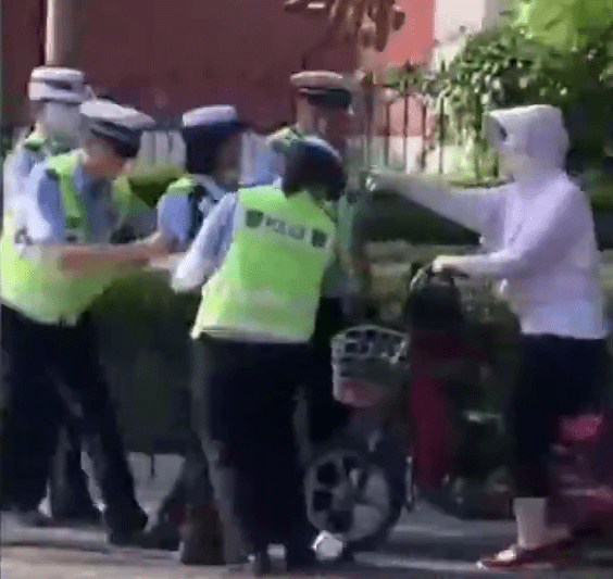骑电动单车的市民与交警发生争执，因其未佩戴头盔不听劝止。