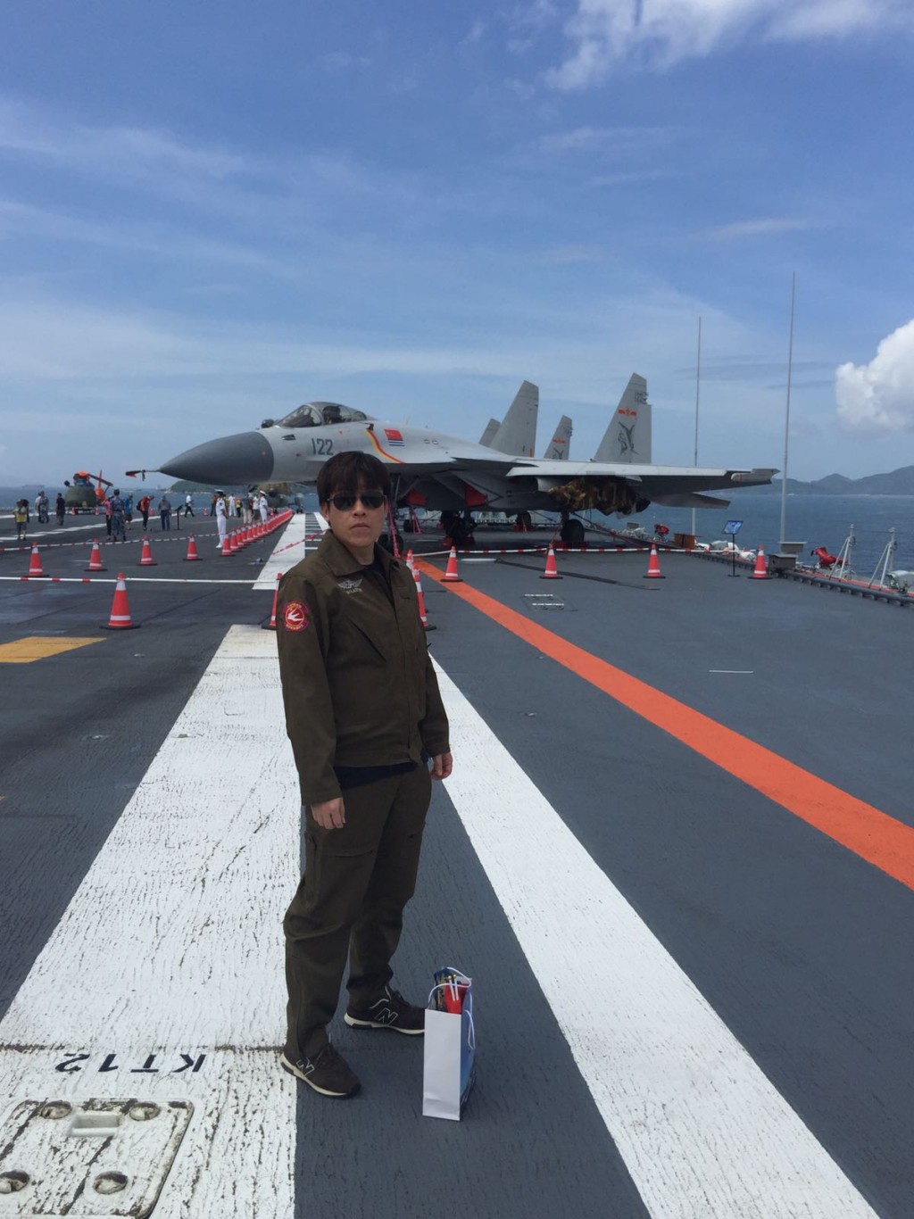 黃先生自備軍褸，到遼寧艦上留影。