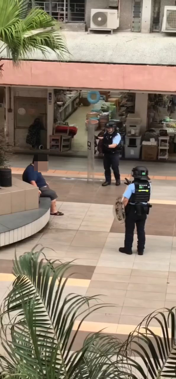 多名戴頭盔的警員持盾牌趕至,要求男子放下菜刀。網上片段截圖 多名戴頭盔的警員持盾牌趕至,要求男子放下菜刀。網上片段截圖