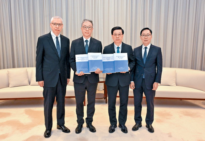 行政長官李家超（右二）收到就大埔宏福苑火災成立的獨立委員會主席陸啟康（左二）、委員陳健波（右一）及歐陽伯權（左一）呈交的報告。
