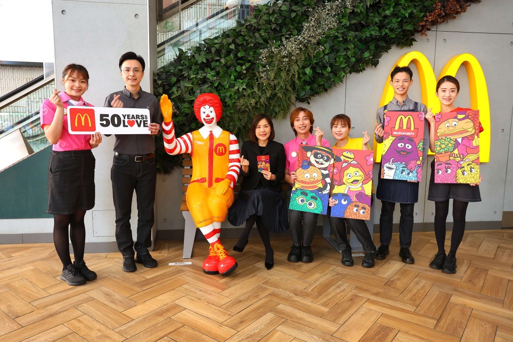 香港麥當勞行政總裁黎韋詩（中）與餐廳前線團隊於麥當勞叔叔長櫈合影。