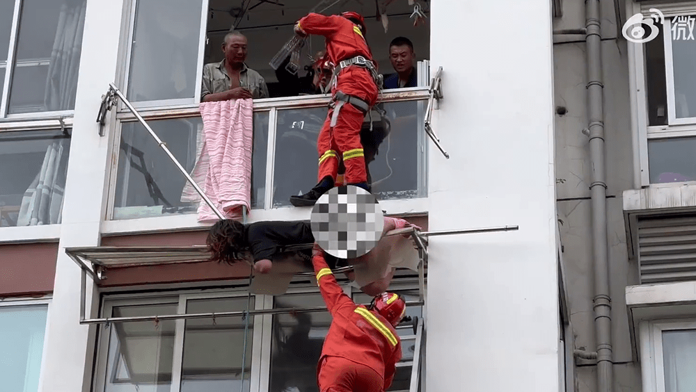 一组消防员从窗口接应。