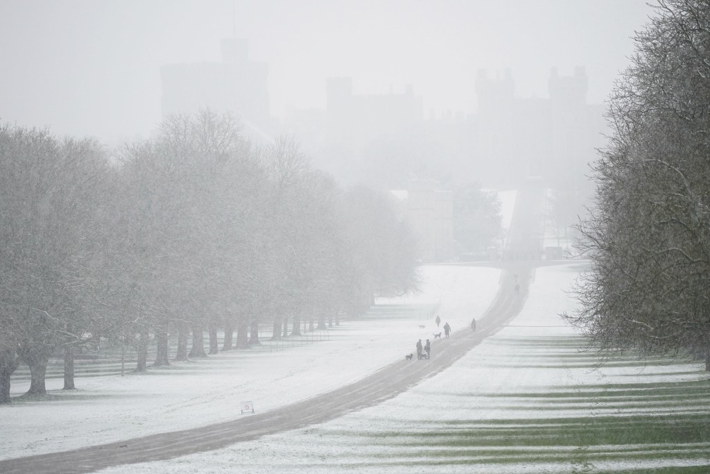 人們沿著伯克郡溫莎城堡的長途步道在雪中行走。AP