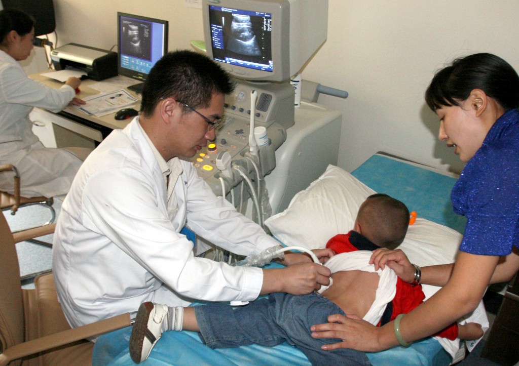 云南结石病医院医生为就诊幼儿做双肾超声波扫描。 新华社