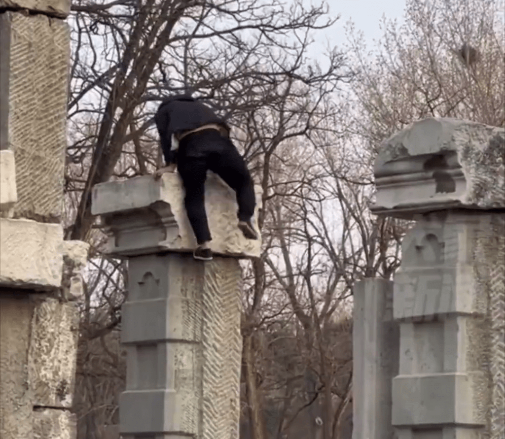 男子從遺址建築爬下來。