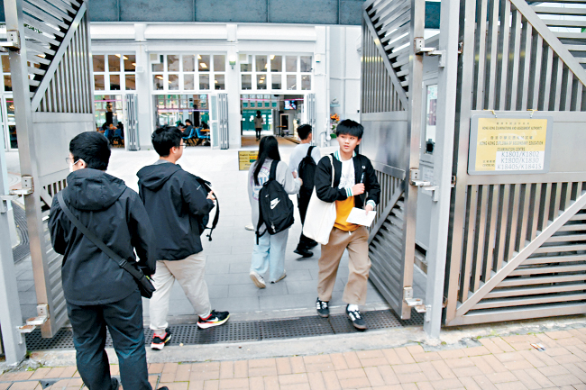 中學文憑試英文科口試昨日正式開考，有考生於試場外拿着書本複習，亦有不少家長陪同子女進入試場。