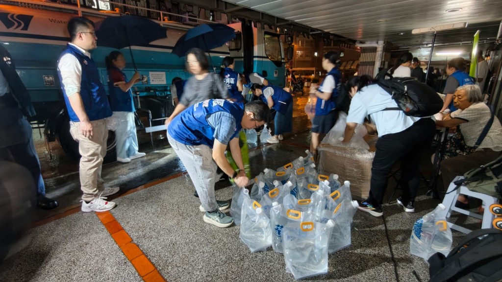 關愛隊冒雨到樓下取水備用。黃文威攝