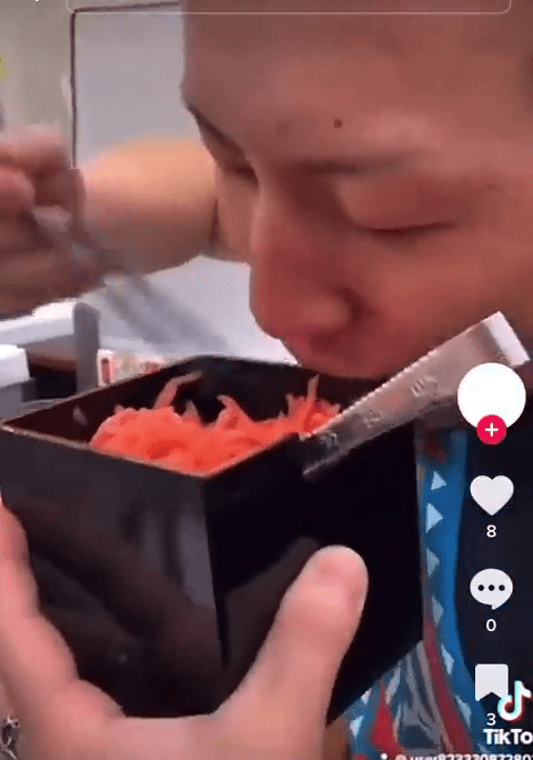 男子用筷子扒共用容器中的红生姜食用。网片截图