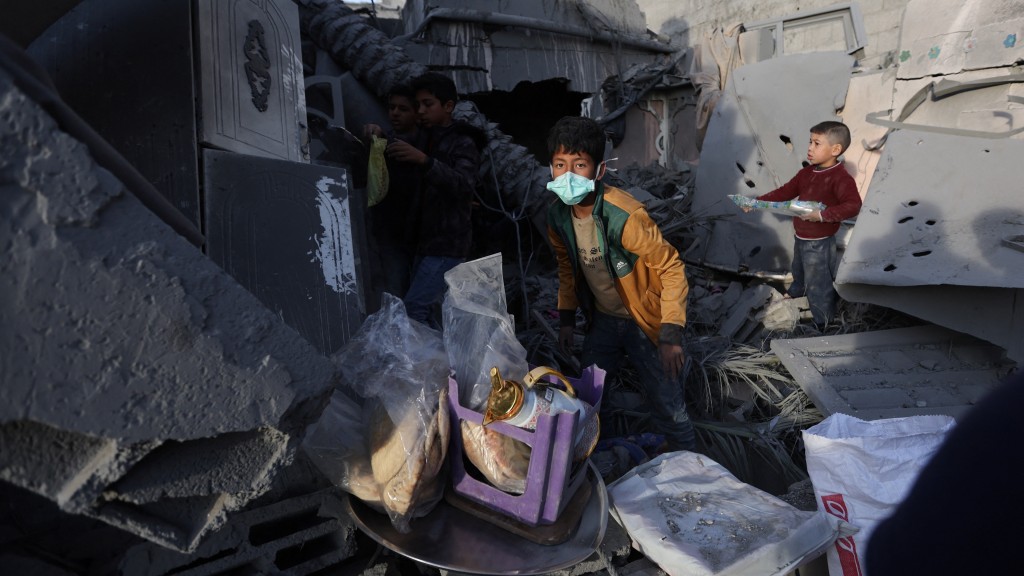 以軍空襲加沙拉法，孩子嘗試在瓦礫中拾回個人物品。 路透社
