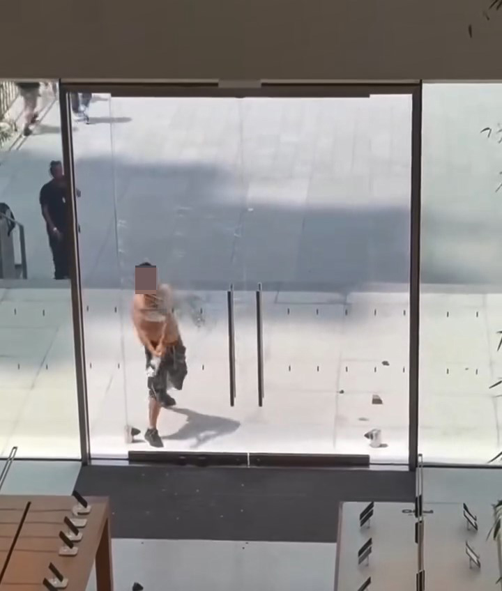 男子手持硬物敲打Apple專門店的玻璃門。網上片段截圖
