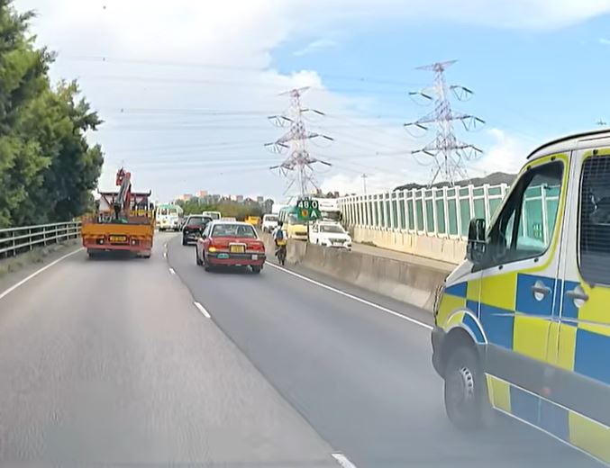 警车前方惊现男子踩着电动自行车。fb车cam L（香港群组）影片截图