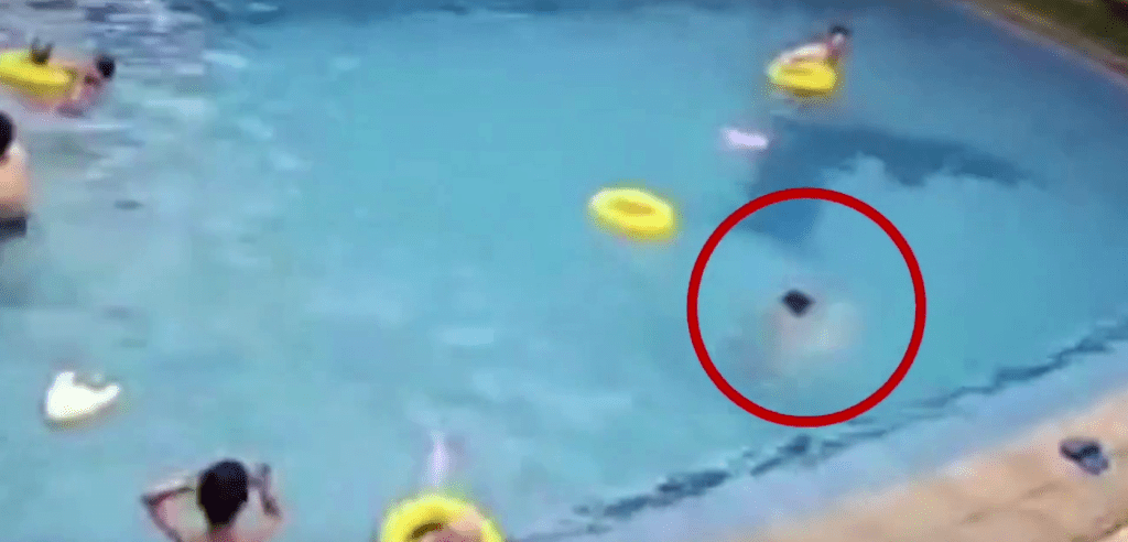 男孩翻身时游泳圈脱手，飘往远处，在水中不停挣扎。