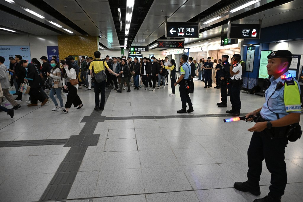 警員及港鐵職員在站內指示乘客入閘。