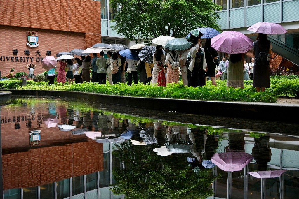 不少遊客冒雨在港大百周年校園及大學街「打卡」。蘇正謙攝
