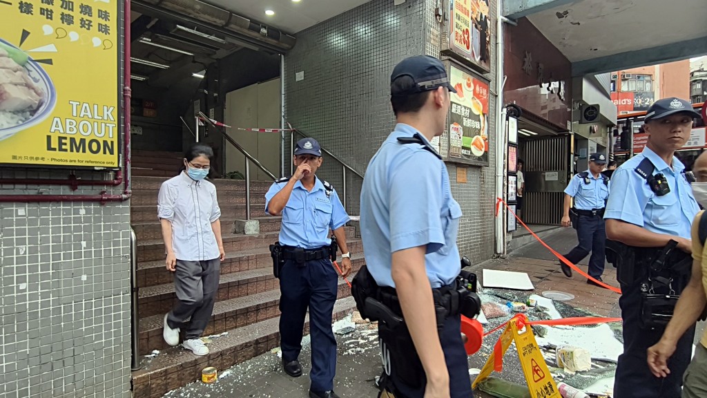 警方帶走一名女店員。徐裕民攝 警方帶走一名女店員。徐裕民攝