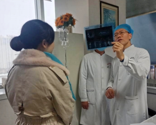 西安一名醫生邊吊鹽水,邊為病人診症。網圖