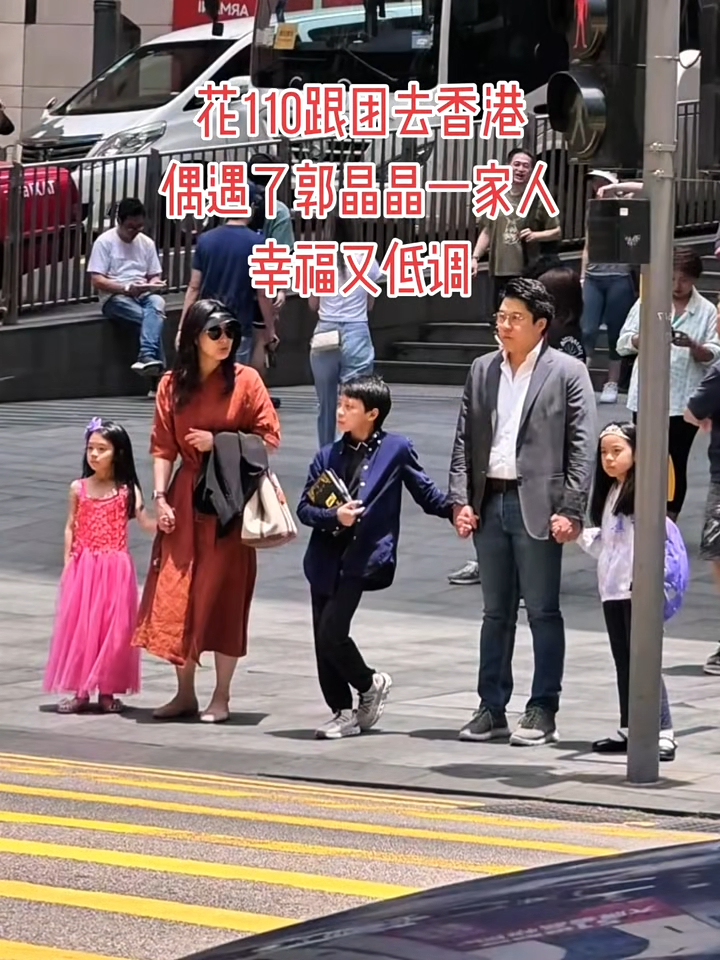 郭晶晶頭戴黑色遮陽帽並身穿橘紅色連身長裙,而霍啟剛則穿著一身深灰色西裝,夫婦二人各自拖著兒女,一家五口在路邊等候紅綠燈過馬路,十分遵守交通規則。 郭晶晶頭戴黑色遮陽帽並身穿橘紅色連身長裙,而霍啟剛則穿著一身深灰色西裝,夫婦二人各自拖著兒女,一家五口在路邊等候紅綠燈過馬路,十分遵守交通規則。