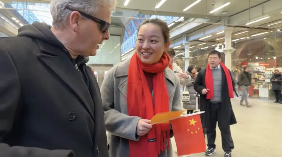 涉事华人手持中国国旗，其中一人表示他们来到是为了中国节目摄制。