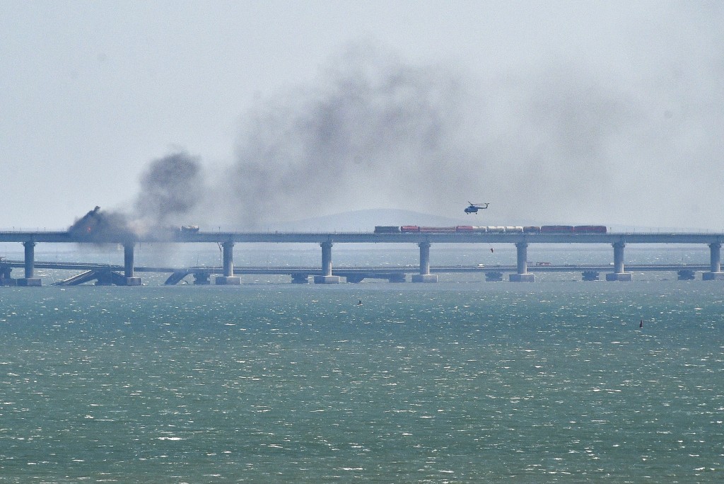 克里米亚大桥在爆炸后起火，霎时浓烟四溢，大桥部分结构崩塌落入海中。AP