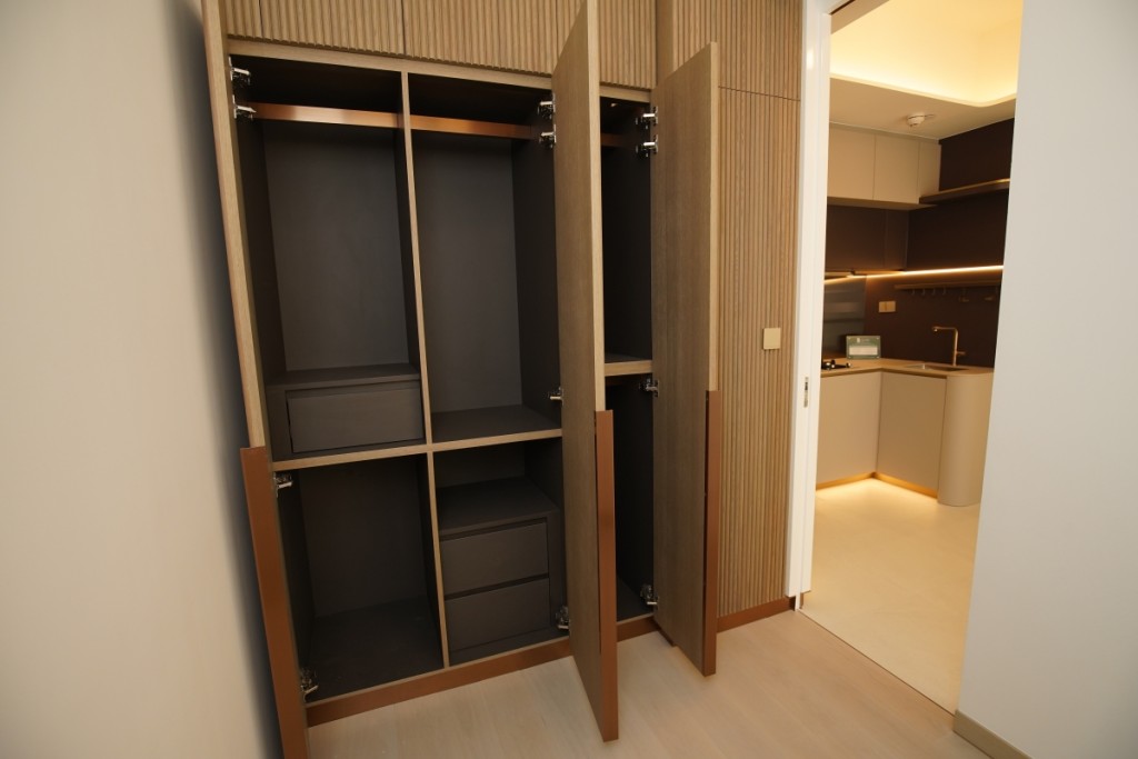 入牆式大衣櫃高至天花板，內置多元化掛衣空間及衣物存放間隔。