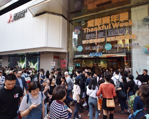 大批旅客拖篋排隊入場掃貨。