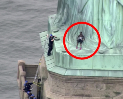 美國國慶日一名黑人女子爬上紐約自由女神像，坐在神像裙腳抗議，不滿政府移民政策。AP