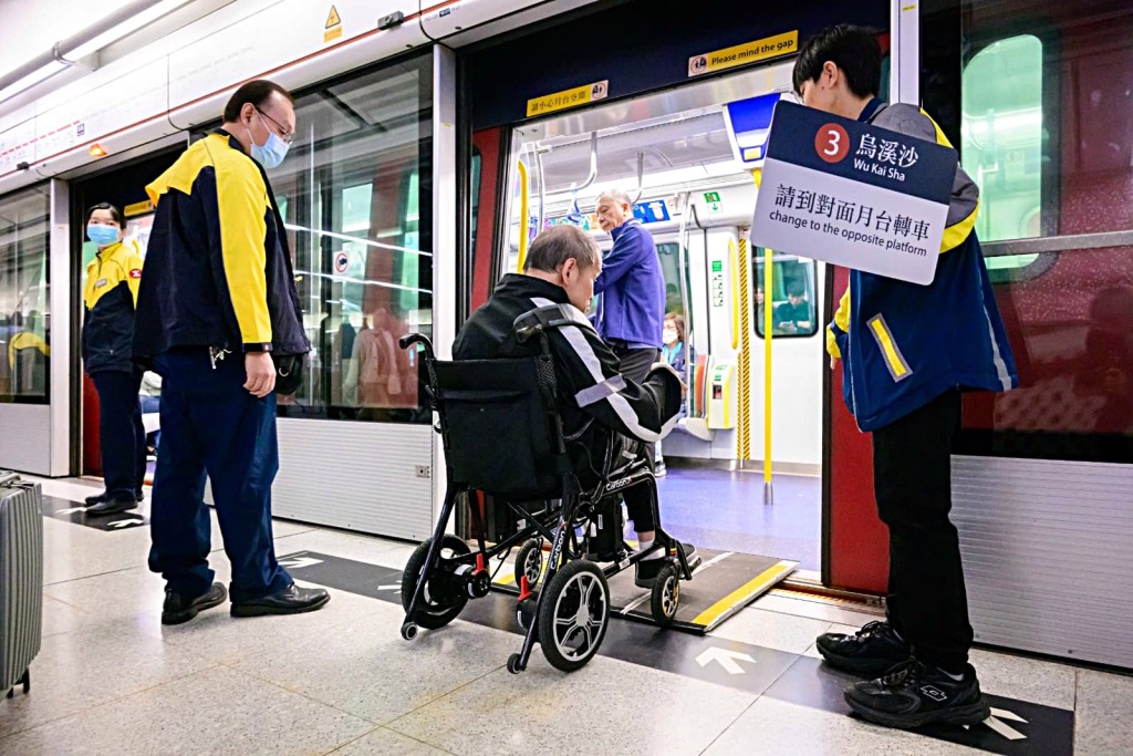 港鐵職員協助有特別需要的乘客包括視障及使用輪椅的乘客轉車。 港鐵職員協助有特別需要的乘客包括視障及使用輪椅的乘客轉車。