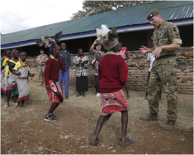 威廉王子到访一间学校和小学生踢波。AP 