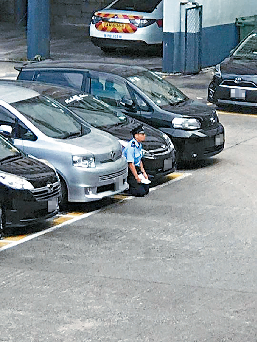 ﻿■一名軍裝警員手持標語跪在警署露天停車場，即使下雨，他仍手持標語請願（小圖），引來網民議論紛紛。
