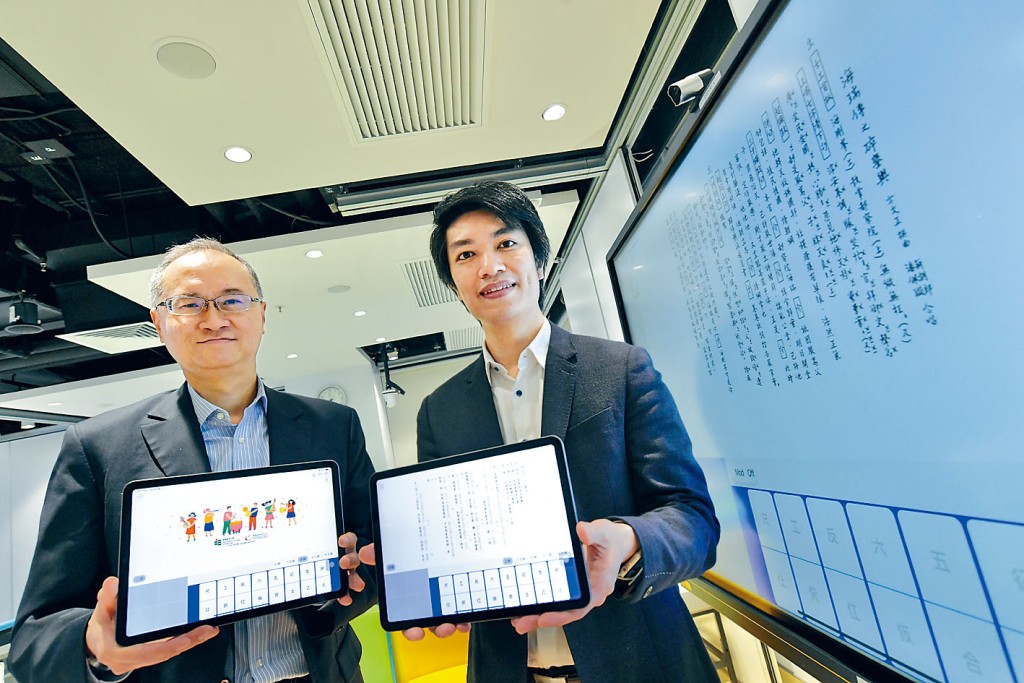 梁寶華(右)指「粵曲拍和」應用程式,有助師生認識粵曲。旁為參與研發的梁智軒。