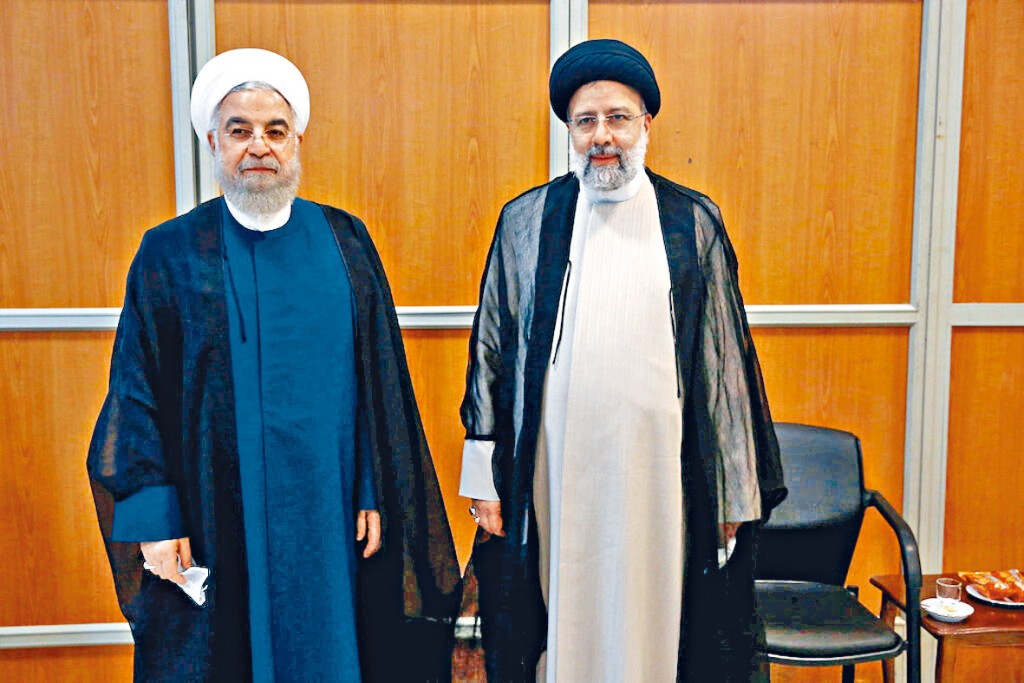 伊朗新總統萊希（右），周二與前總統魯哈尼合照。