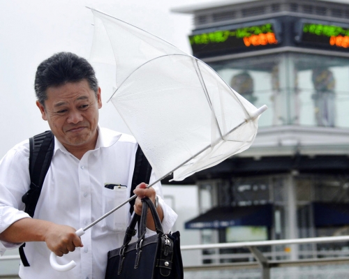 磐城市民眾外出遇狂風大雨。AP圖片