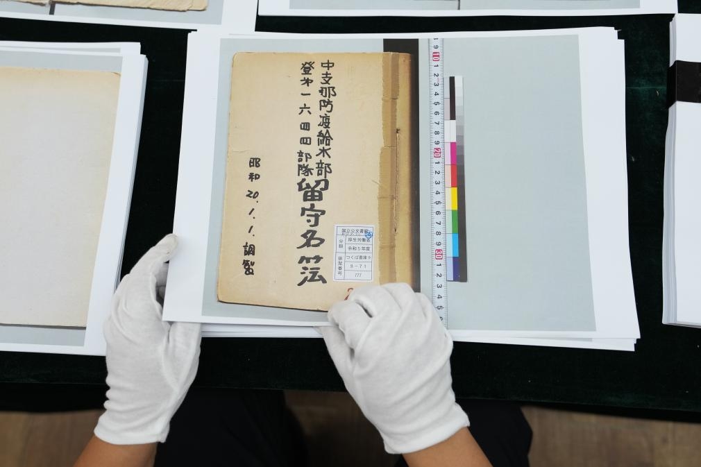 工作人員展示1644部隊《留守名簿》（影印件）。新華社