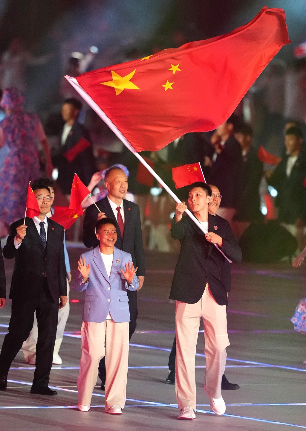 国家队由男子篮球运动员胡明轩（右）和女子拳击运动员吴愉（左）持旗。新华社