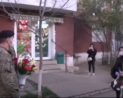 羅馬尼亞醫護遭鄰居淋消毒水,士兵獻花代致歉。影片截圖