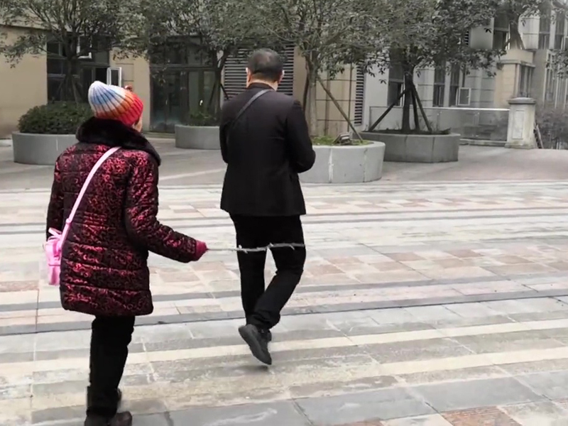 两母子现出门，杜男都让母亲拿着木条在后面赶他，觉得这样可帮助唤起母亲打自己的记忆。（网图）