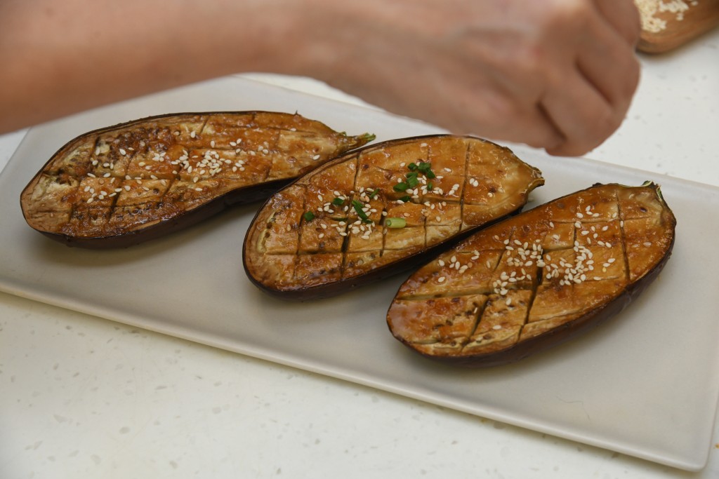Step 8: 茄子上碟，洒上芝麻粒和葱花，即成。 Dish up the eggplant. Sprinkle with sesame seeds and chopped spring onion and serve.