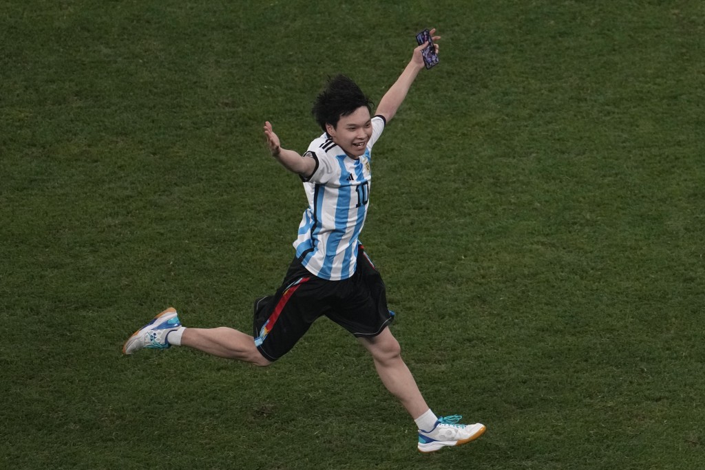 该名球迷以庆祝世界杯入球的姿态举高双手疯狂奔跑。 美联社