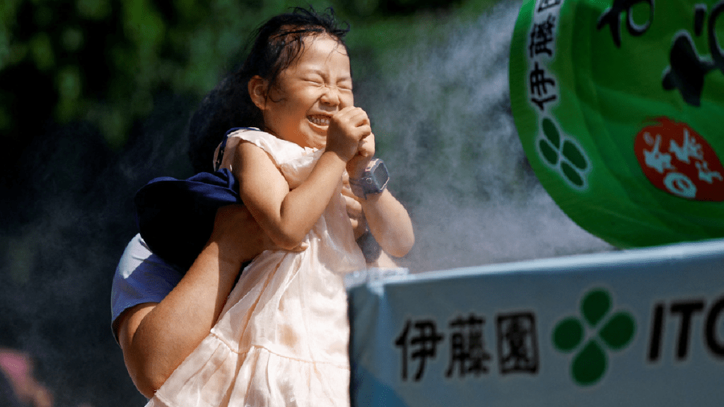 日本一個女童在噴霧器前降溫。（路透社）