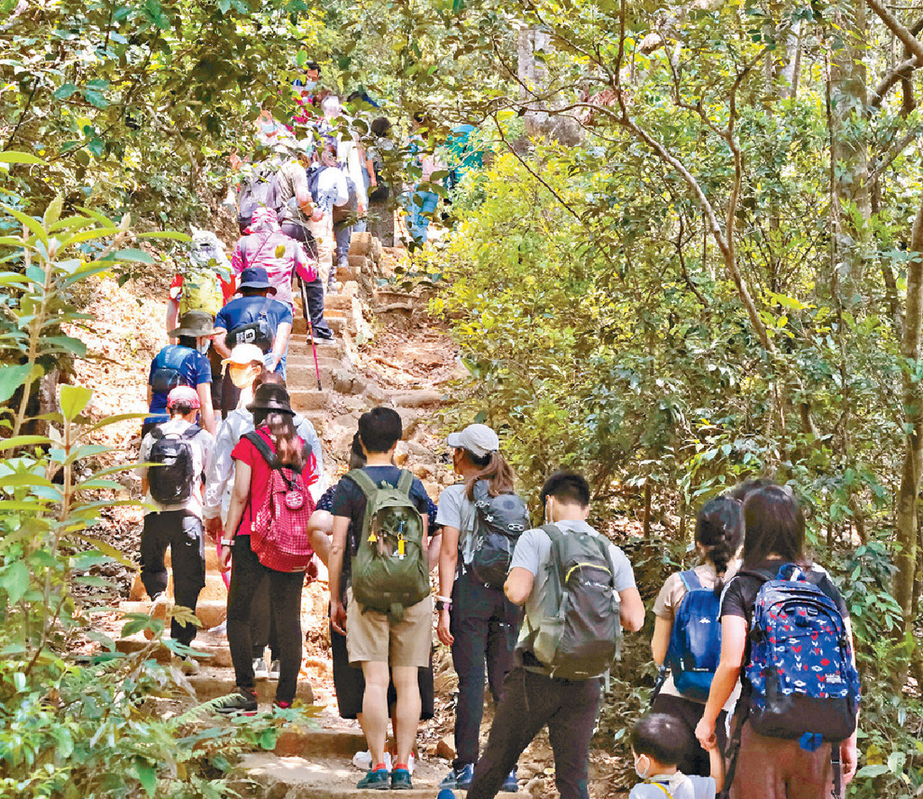 行山「唞氣」■大批港人在疫情回穩時，選擇行山郊遊「唞氣」，山頭場面墟冚。陳極彰攝