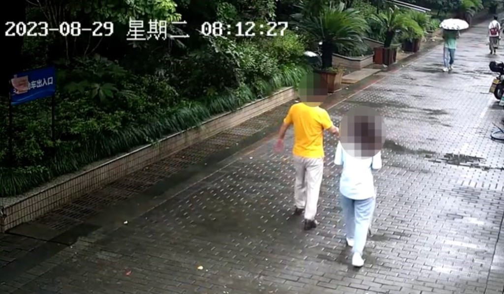老李（黄衣男）接小张（蓝衣女）上楼。红星新闻