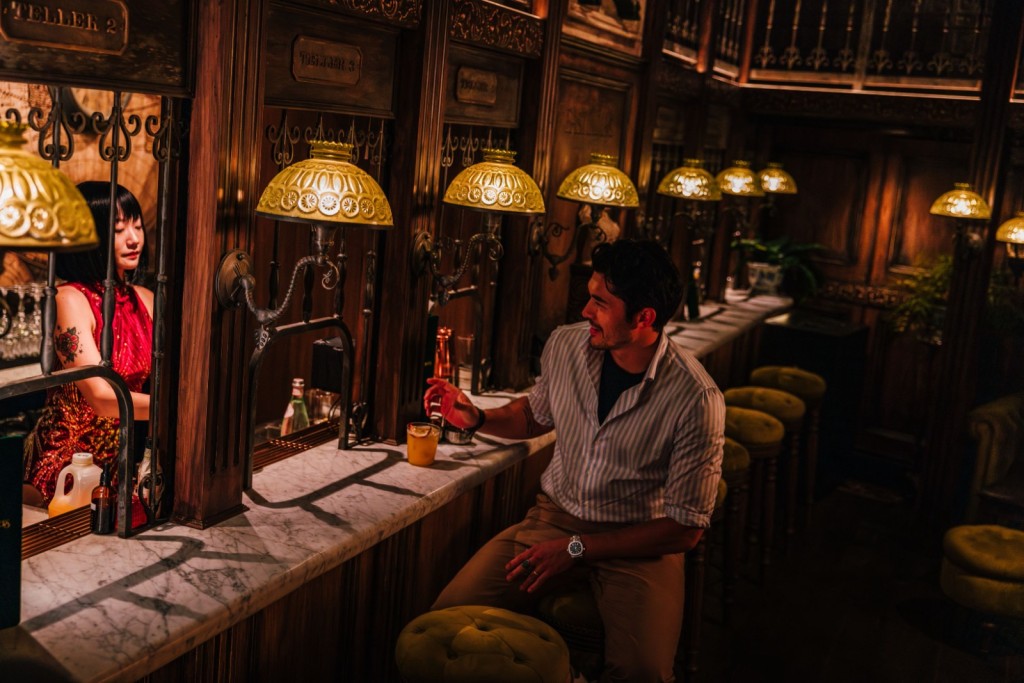 亨利高汀到訪特色酒吧，調酒師站在「舊銀行」櫃檯為他調製雞尾酒。