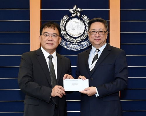 警務處處長盧偉聰(右)頒授委任狀予新任輔警副總監鄭文森(左)。香港警務署提供