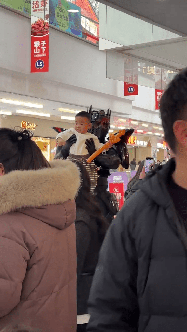 周高賽穿上機甲「戰衣」與民眾合照，令他倍感自豪。 抖音