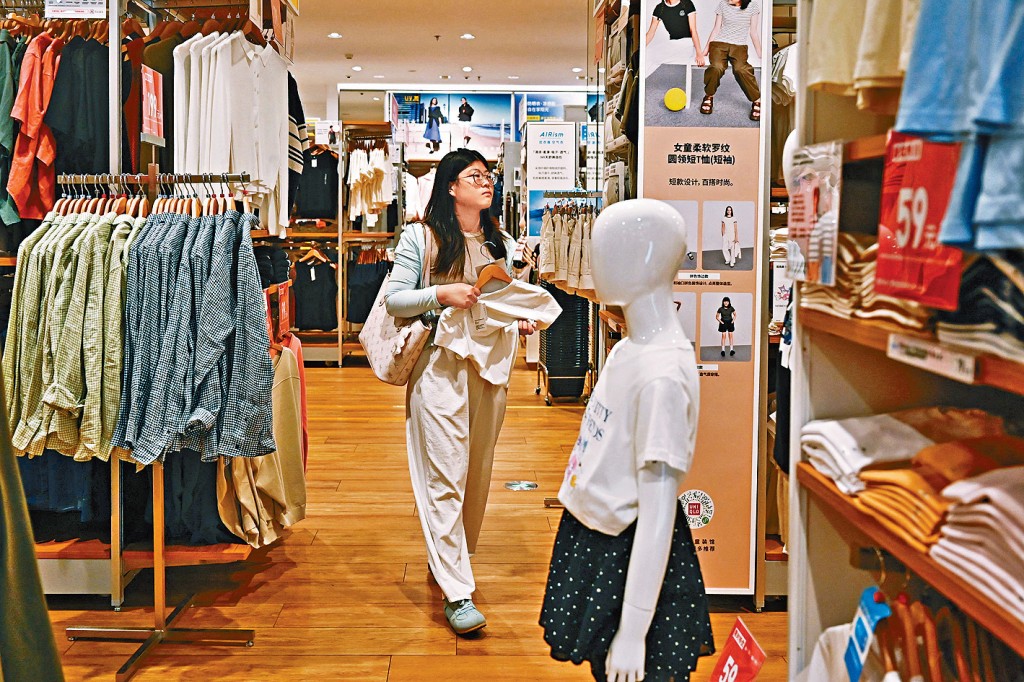 女子在日企優衣庫北京分店內挑選衣服。