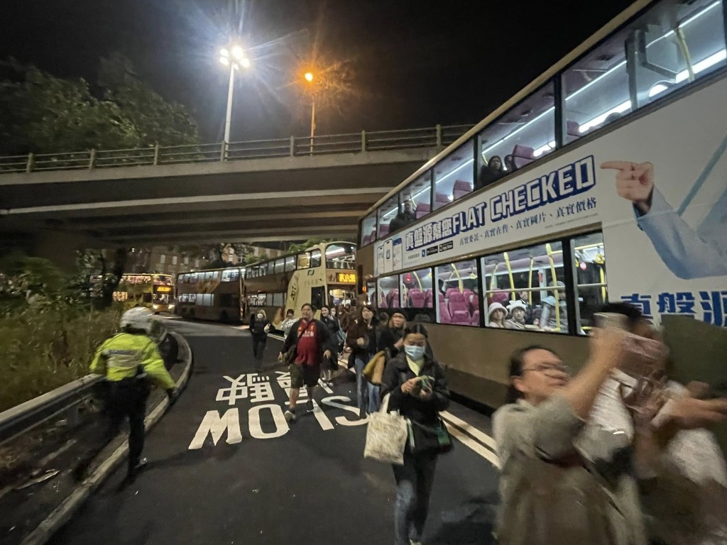 多名乘客在警方指揮下下車，沿馬路步行離開現場。FB 香港突發事故報料區及討論區 圖片