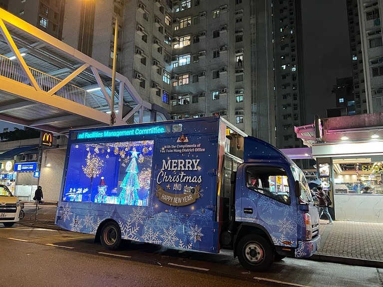 流动灯饰车车身为蓝色，上面印有大量雪花及写有「Merry Christmas and Happy New Year」的图案
