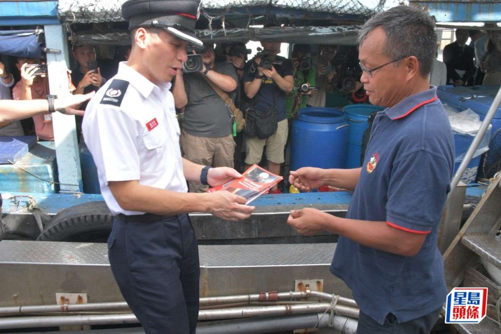 消防處代表向香港仔南避風塘船家派發防火宣傳小冊子。 楊偉亨攝