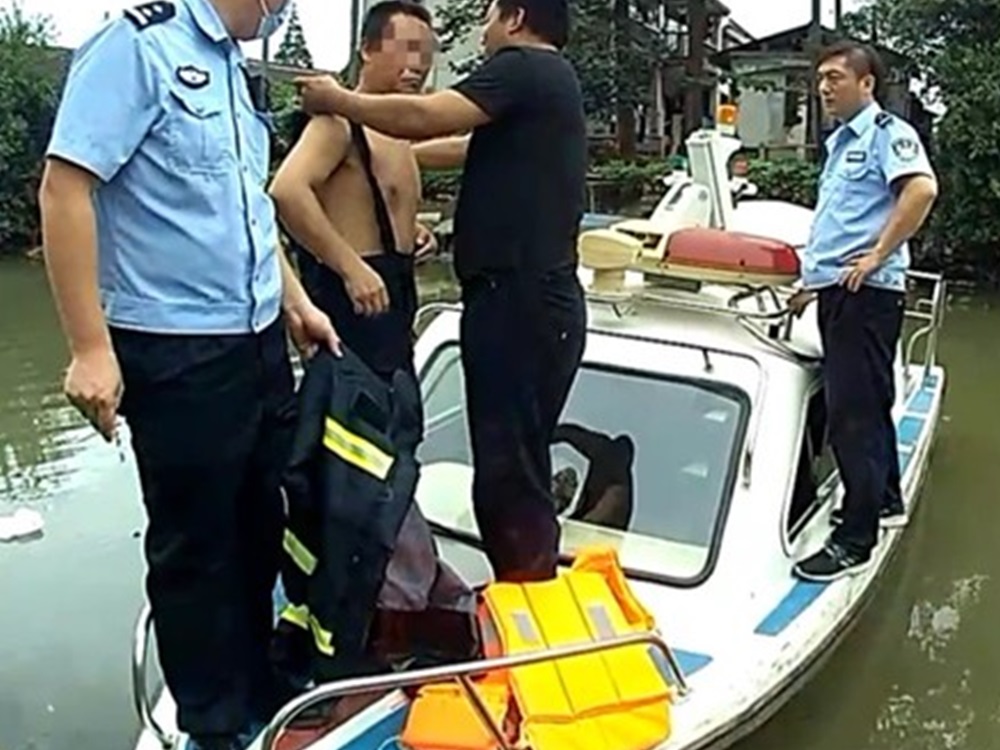 當地警員派小艇到河道,將男子帶上船。網圖